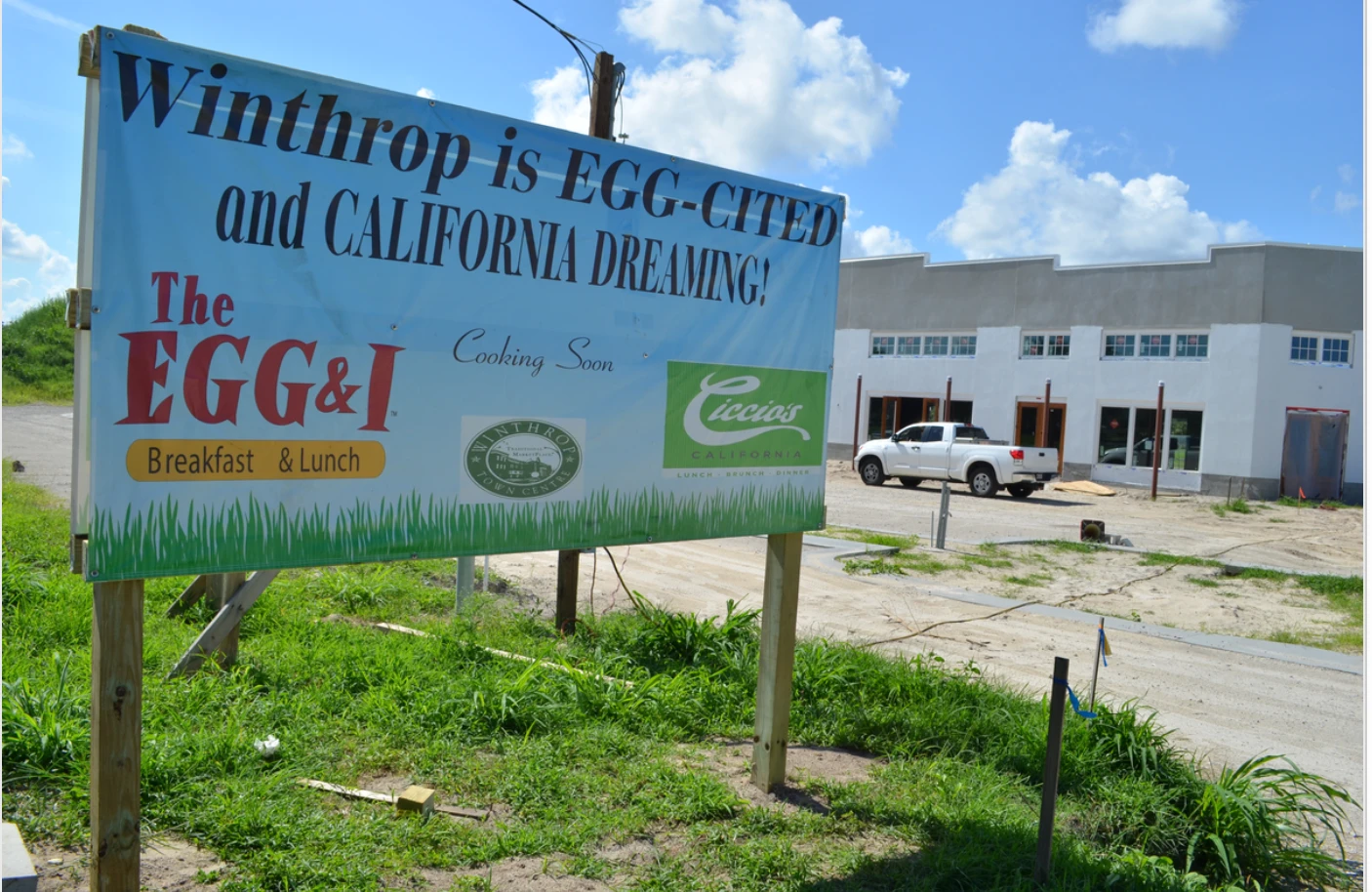 A 'Winthrop is EGG-CITED and CALIFORNIA DREAMING!' banner announcing The Egg & I and Ciccio's California (now Cali) as 'Cooking Soon' at Winthrop Town Centre, with the under-construction building visible behind the sign