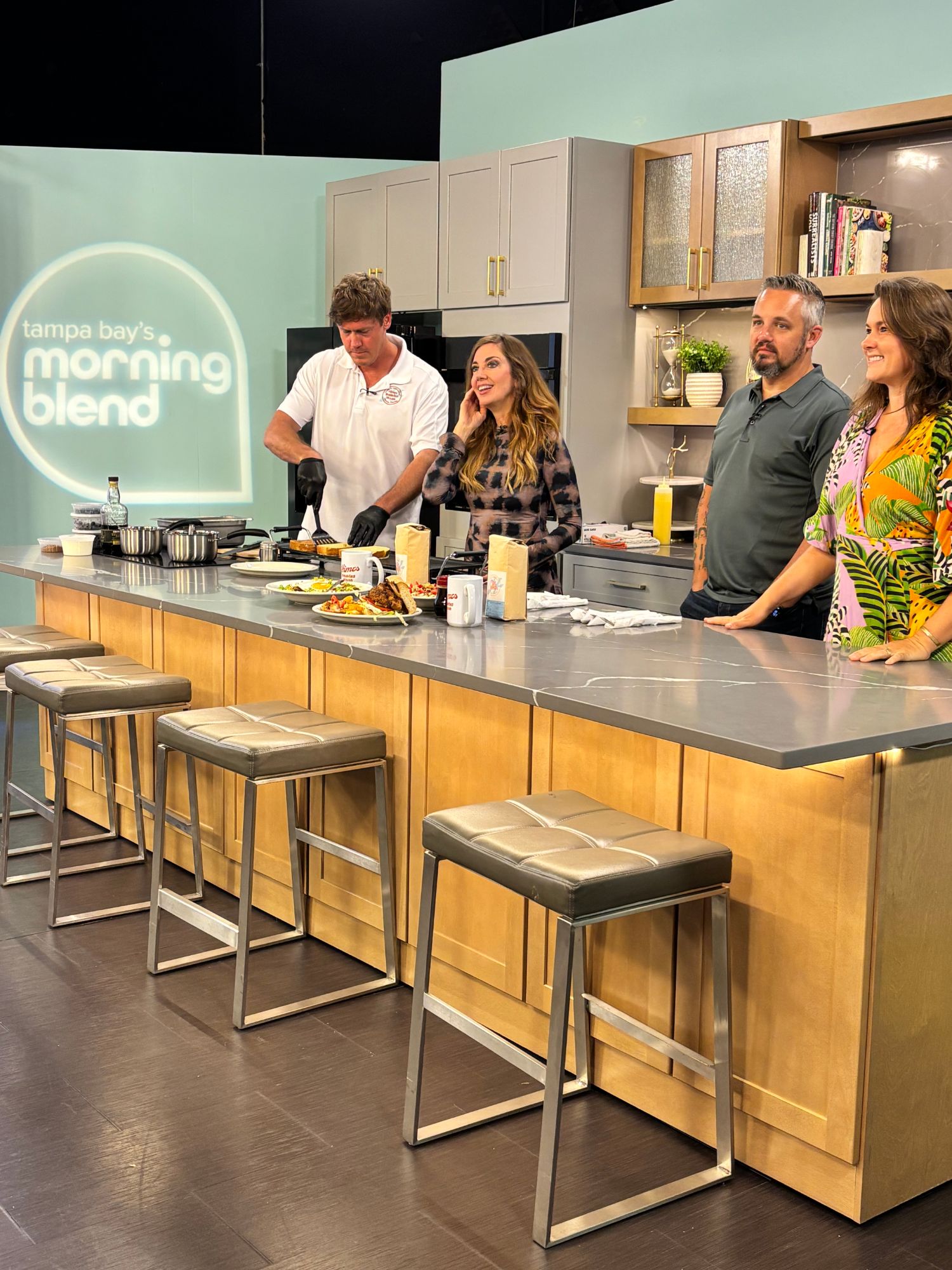 John Christen of Himes Breakfast House cooking Banana Foster French Toast live on the Tampa Bay's Morning Blend set, with the Morning Blend host, John Camisa of Donovan's Meatery, and Sarah Sullivan Xiong of Winthrop looking on