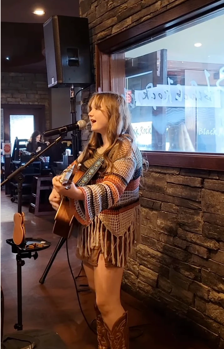 Paisley Grace singing and playing acoustic guitar at a small-venue performance ahead of her PG-13 Tour stop at the Winthrop Barn Theatre on November 1, 2026 in Riverview, Florida
